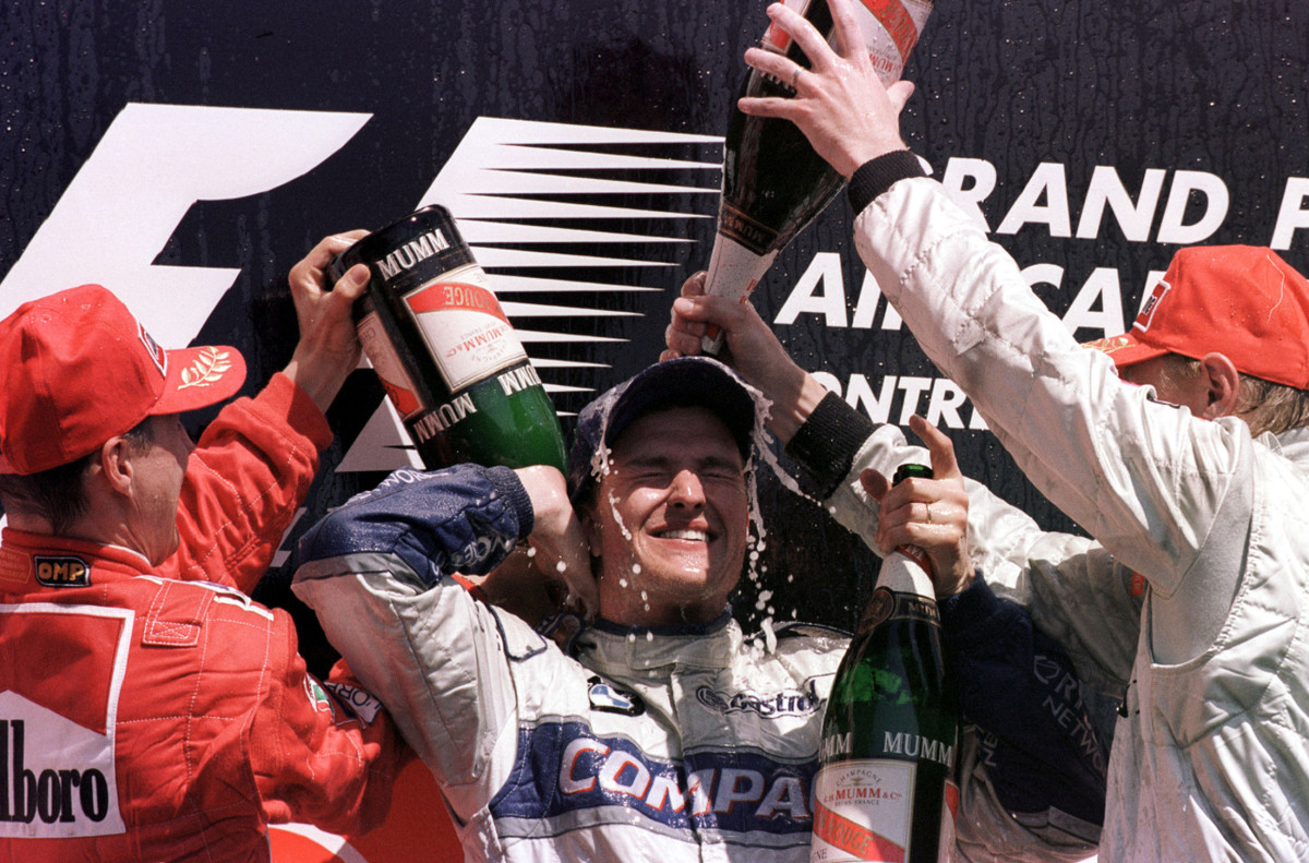 Подиум Гран-при Канады 2001: Михаэль Шумахер (2 место) и Мика Хаккинен (3 место) обливают шампанским победителя гонки - Ральфа Шумахера