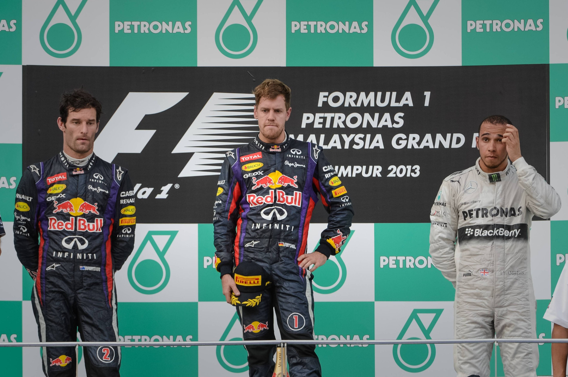 Подіум Гран-прі Малайзії 2013: Марк Веббер (2 місце), Себастьян Феттель (1 місце) і Льюїс Гамільтон (3 місце)
