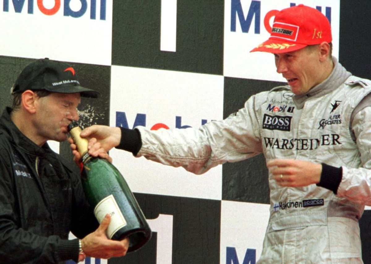 Мика Хаккинен угощает Эдриана Ньюи победным шампанским