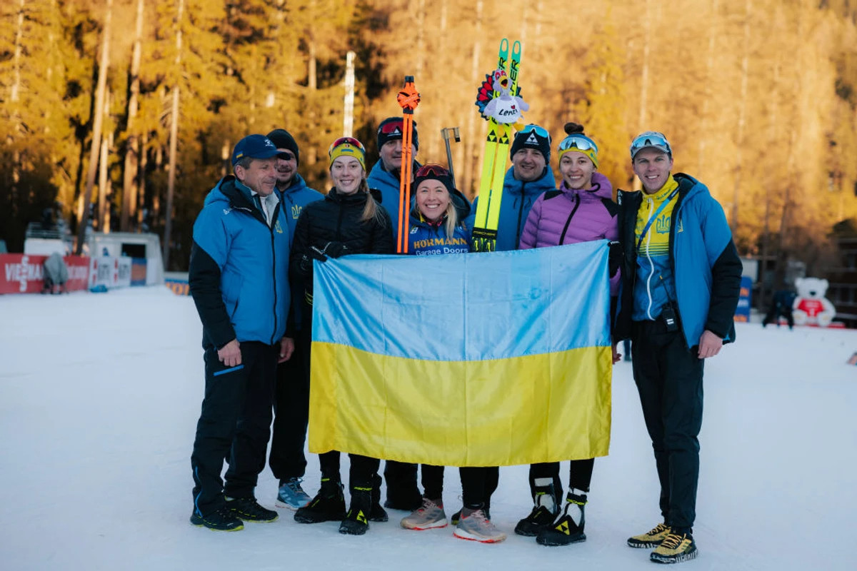 Христина Дмитренко, Юлія Джима та Олена Городна разом із прапором України та тренерами збірної