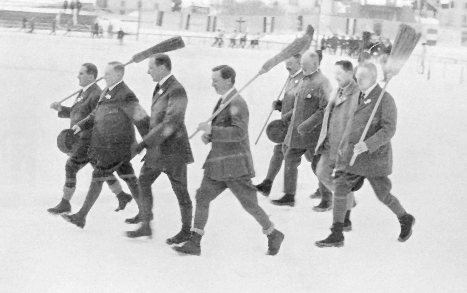 Шамоні (Франція). 1924 рік. Церемонія відкриття зимової Олімпіади. Повз головну трибуну крокують із мітлами майстри керлінгу.