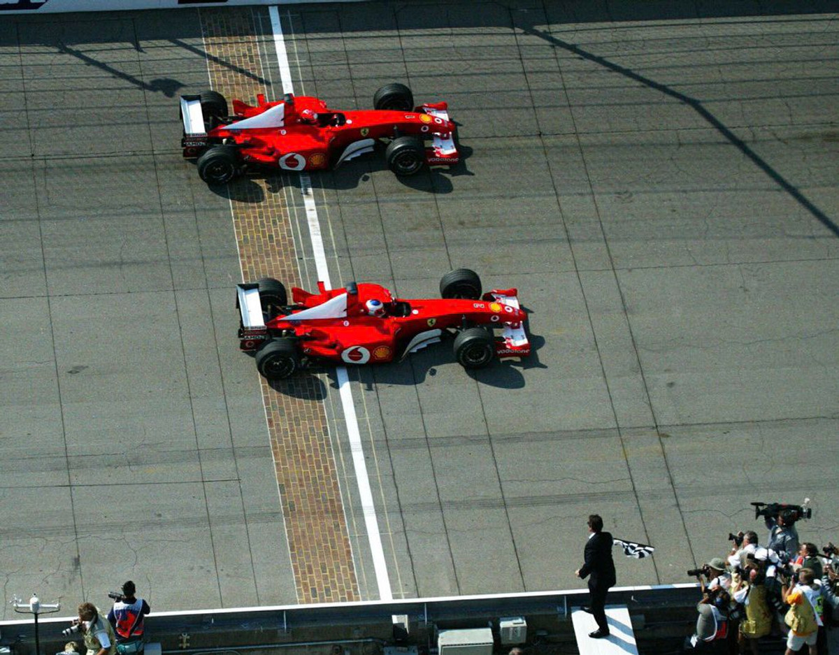 Михаэль Шумахер (дальше) вернул долг Рубенсу Баррикелло (ближе) на Гран-при США 2002